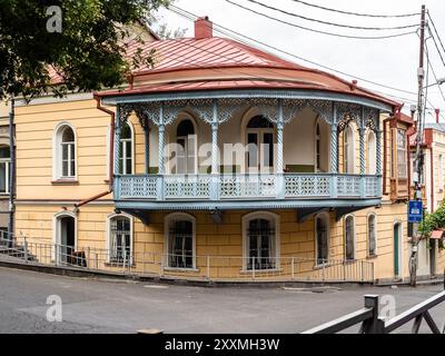 Vieille maison de ville avec balcon en bois ajouré sur la rue de la vieille ville de Tbilissi le jour couvert d'été, Géorgie Banque D'Images
