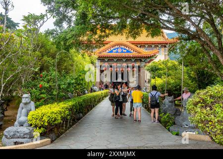 Les gens marchent le long d'un chemin à travers un jardin approchant l'un des temples colorés du complexe du temple Kek Lok si à Penang, en Malaisie Banque D'Images