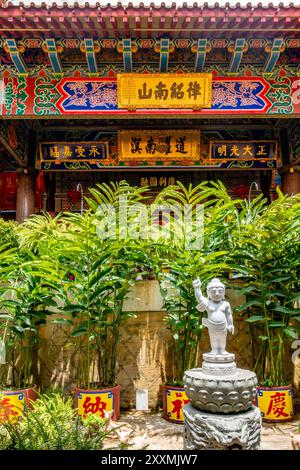 Une figure de pierre pointe vers l'un des temples du complexe de temples Kek Lok si à George Town, Penang, Malaisie Banque D'Images