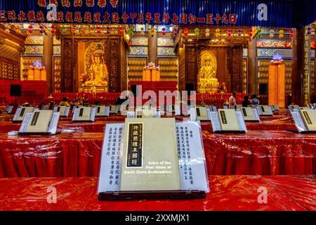 Rangées de livres de prières mis en place pour les fidèles dans la salle de prière principale du temple Kek Lok si, un temple bouddhiste à Penang, en Malaisie Banque D'Images