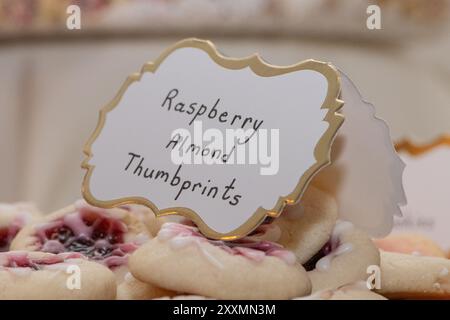 Signe blanc avec garniture dorée qui lit 'empreintes digitales d'amande rasberry' sur de délicieux biscuits Banque D'Images