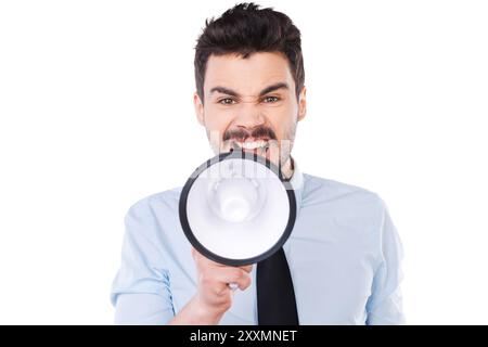 Tout le monde m'écoute ! Jeune homme furieux en chemise et cravate tenant mégaphone et criant tout en se tenant debout sur fond blanc Banque D'Images
