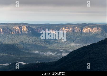 À travers la Jamison Valley se trouvent les falaises de grès du Kings Tableland, un plateau dans le parc national des Blue Mountains en Nouvelle-Galles du Sud, en Australie Banque D'Images