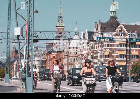 Femmes à vélo lors d'une journée d'été ensoleillée à Copenhague, Danemark Banque D'Images