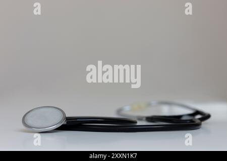 stéthoscope avec un tube noir repose sur un fond blanc. Mise au point sélective Banque D'Images