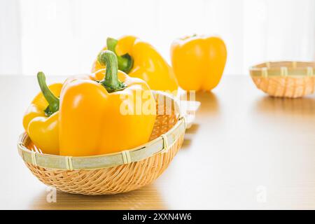 Poivron jaune douce (capsicum) dans panier sur table en bois Banque D'Images