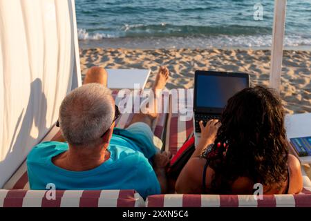 Un couple marié allongé sur un lit de repos. Affaires et vacances d'été Banque D'Images