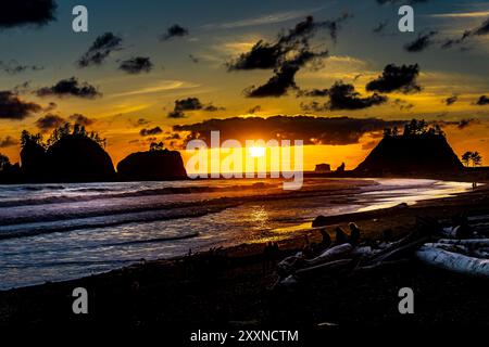 Au Quileute Oceanside Resort à la Push, Washington, regardant vers le nord le long de la rive au crépuscule. Un beau coucher de soleil lumineux à travers quelques nuages. Banque D'Images