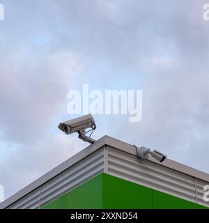 Caméras de surveillance au coin du toit d'un bâtiment industriel. Banque D'Images