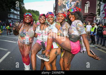 Londres, Royaume-Uni. 25 août 2024. Un groupe de dames profite de leur temps au carnaval couvert de peintures brillantes dans le cadre des célébrations du mas de J'ouvert, une tradition du carnaval des Caraïbes en particulier à Trinidad. L'habituel dimanche matin J'ouvert a été annulé, mais les fêtards ont encore célébré plus tard. Le dimanche du carnaval de Notting Hill a commencé avec le traditionnel carnaval des enfants aujourd'hui et plus tard, les fêtards ont célébré le week-end des vacances bancaires en participant ou en regardant le long de la route du carnaval, dans les systèmes de sonorisation, les stands et les lieux. Crédit : Imageplotter/Alamy Live News Banque D'Images