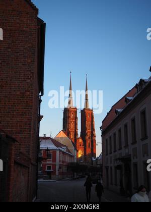 Wroclaw, Pologne - 20 janvier 2024 : L'image montre une vue saisissante de tours cathédrales gothiques jumelées baignées d'une lueur chaude de coucher de soleil, vue d'un co Banque D'Images