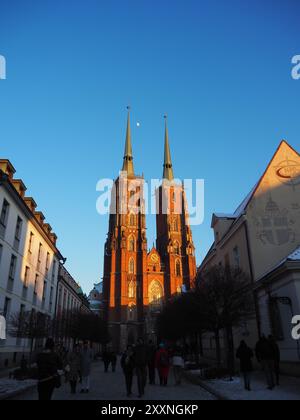 Wroclaw, Pologne - 20 janvier 2024 : L'image montre une vue saisissante de tours cathédrales gothiques jumelées baignées d'une lueur chaude de coucher de soleil, vue d'un co Banque D'Images