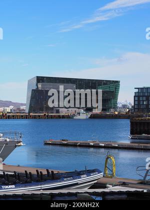 Reykjavik, Islande - 9 mai 2024 : une scène portuaire moderne avec des yachts élégants amarrés près d'un bâtiment frappant aux motifs géométriques colorés, Under Banque D'Images