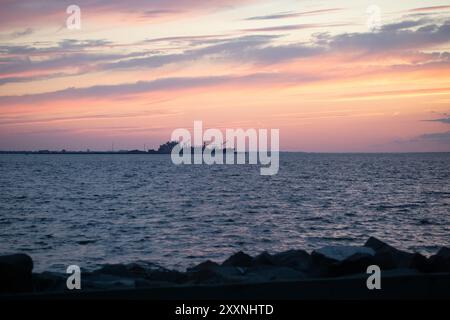 Un beau coucher de soleil est vu sur la baie au large de la côte de Sandy Hook et Fort Hancock le 10 août 2024. Banque D'Images