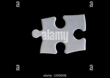 une seule pièce d'un puzzle sur un fond noir Banque D'Images