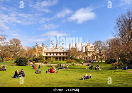 Brighton, Royaume-Uni - 16 avril 2012 : touristes sur l'herbe profitant d'un jour de printemps devant le pavillon historique de Brighton. Banque D'Images