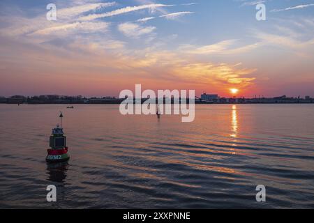 Vue sur la Warnow jusqu'au port de pêche de Rostock au coucher du soleil Banque D'Images