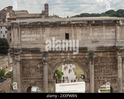 Vue d'un arc de triomphe avec inscriptions gravées et touristes en arrière-plan, Rome, Italie, Europe Banque D'Images