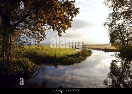 Rayons de soleil après le lever du soleil sur le canal à l'automne Banque D'Images