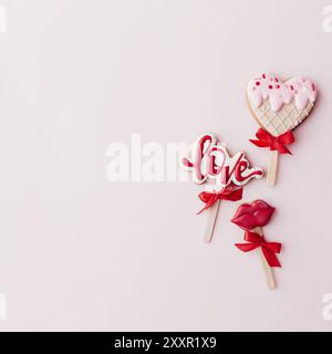 Biscuits au pain d'épices amour, lèvres, crème glacée coeur. Carte de Saint-Valentin. Fond rose. Banque D'Images