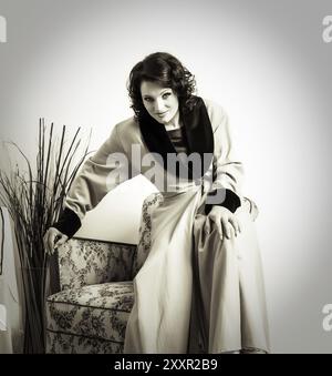 Femme habillée dans le style des années cinquante dans une robe de chambre jaune Banque D'Images