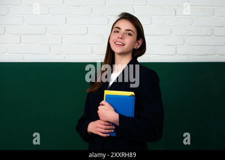 Le nouveau professeur vérifie les devoirs. Étudiante attirante ou nouvelle enseignante. Apprentissage de la langue et concept d'éducation. Jeune enseignante. Le Banque D'Images