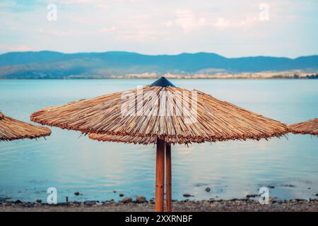 Parasols Reed à la plage sur le lac Dojran en Macédoine du Nord, foyer sélectif Banque D'Images