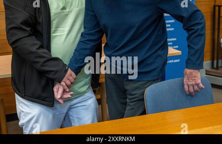 Traunstein, Allemagne. 26 août 2024. Un homme de 93 ans atteint de démence (R) est conduit à son siège dans la salle d'audience du tribunal de district de Traunstein par une escorte avant le début du procès. L'homme est accusé d'avoir tué son colocataire dans une maison de retraite à Wasserburg am Inn en janvier 2024. L'accusé aurait agressé physiquement et étouffé son colocataire, qui était couché dans son lit, parce qu'il ne voulait pas partager la chambre avec lui. Au total, quatre jours de procès ont été prévus. Crédit : Peter Kneffel/dpa/Alamy Live News Banque D'Images