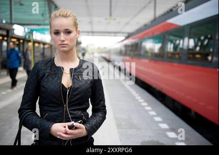 Jeune adulte, femme blonde sur la gare centrale. Younf adulte, femme blonde sur la gare centrale attendant son train Intercity & Fyra vers sa destination. Rotterdam, pays-Bas. MRYES Rotterdam Centraal Station Zuid-Holland Nederland Copyright : xGuidoxKoppesxPhotox Banque D'Images