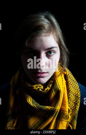 Studio Portrait jeune femme avec châle Studio Portrait & Headshot d'une jeune femme adulte portant un châle jaune devant un fond noir. Tilburg, pays-Bas. MRYES Tilburg Studio Tuinstraat Noord-Brabant Nederland Copyright : xGuidoxKoppesxPhotox Banque D'Images