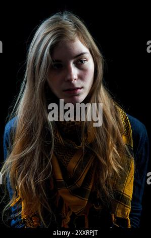 Studio Portrait jeune femme avec châle Studio Portrait & Headshot d'une jeune femme adulte portant un châle jaune devant un fond noir. Tilburg, pays-Bas. MRYES Tilburg Studio Tuinstraat Noord-Brabant Nederland Copyright : xGuidoxKoppesxPhotox Banque D'Images