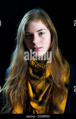 Studio Portrait jeune femme avec châle Studio Portrait & Headshot d'une jeune femme adulte portant un châle jaune devant un fond noir. Tilburg, pays-Bas. MRYES Tilburg Studio Tuinstraat Noord-Brabant Nederland Copyright : xGuidoxKoppesxPhotox Banque D'Images