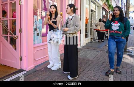 Londres, Royaume-Uni. Deux jeunes chinoises mangeant de la crème glacée dans Carnaby Street Banque D'Images