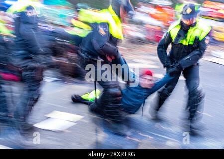 Bloc de la rébellion XR de l'autoroute A12 et Utrechtsebaan les activistes de la rébellion XR bloquent l'autoroute A12 menant à la ville le 11 mars 2023 pour exiger l'interdiction du financement des coopérations sur les combustibles fossiles par le gouvernement national. Puisqu’il s’agissait de la troisième manifestation sur ce spot, Riot & Military police a violemment mis fin au rassemblement de plus de 3,000 militants et partisans. La Haye, pays-Bas. Den Haag, s-Gravenhage, The Hag A12 / Utrechtsebaan Zuid-Holland Nederland Copyright : xGuidoxKoppesxPhotox Banque D'Images