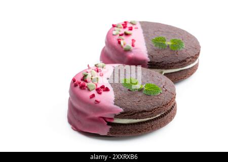 Biscuits au chocolat à la crème et glaçage rose isolés sur blanc Banque D'Images