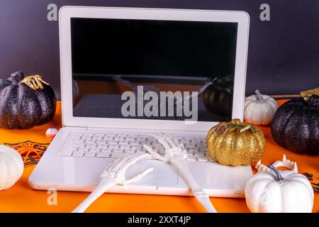 Espace de travail amusant pour Halloween avec pose à plat pour ordinateur portable. Office corporation Halloween partie invitation, blogger automne vacances fond. Ordinateur portable blanc avec Ha Banque D'Images