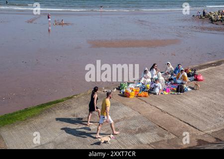 Une famille asiatique pique-niquant sur la promenade de Dawlish Warren, Devon, 2024 Banque D'Images