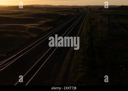 Coucher de soleil sur un paysage de pays pastoral avec des voies ferrées Banque D'Images