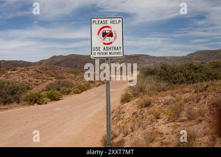 Signalisation routière rappel d'utiliser le cendrier sur le chemin de terre rural Banque D'Images