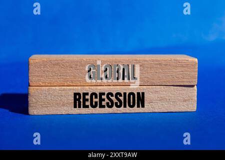 Message de récession mondiale écrit sur des blocs de bois avec fond bleu. Symbole conceptuel de récession mondiale. Copier l'espace. Banque D'Images