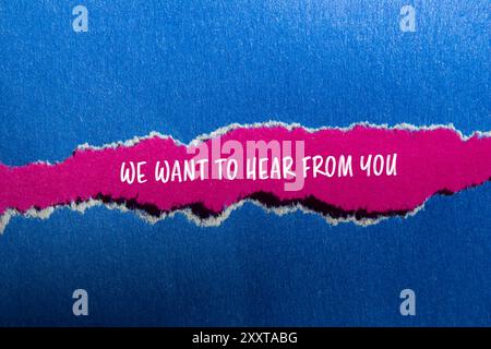 Nous voulons entendre de votre part un message écrit sur papier bleu déchiré avec fond rose. Conceptuel nous voulons entendre de votre part symbole. Copier l'espace. Banque D'Images