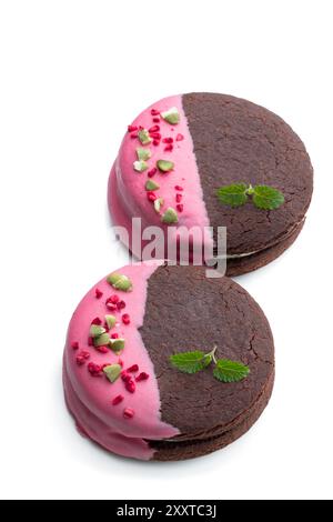 Biscuits au chocolat à la crème et glaçage rose isolés sur blanc Banque D'Images