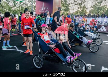 Buenos Aires, Argentine. 25 août 2024. Une jeune femme handicapée motrice sourit à la caméra avec son guide avant le départ. La nouvelle édition du semi-marathon de Buenos Aires est un événement record avec plus de 25 000 participants et 4 146 étrangers. Cette année, le 21 km a été choisi par World Athletics comme l'une des 10 meilleures courses au monde, étant la plus populaire en Amérique du Sud. Le circuit traverse les quartiers emblématiques de la ville. Crédit : SOPA images Limited/Alamy Live News Banque D'Images