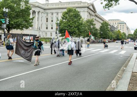 Washington DC, USA - 19/2024 : un groupe de manifestants défilent dans la rue avec des panneaux et des banderoles. Une femme en chemise bleue marche au milieu Banque D'Images