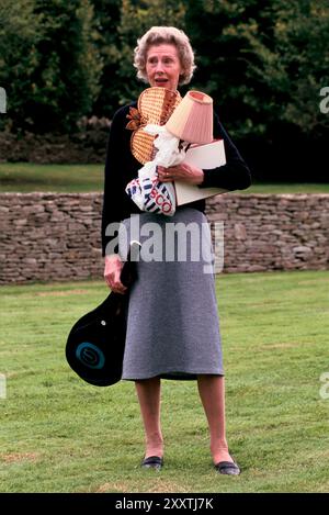 English Village Fete, résidente locale Mme Betty Reid avec des trucs qu'elle fait don à la stalle White Elephant. Eastleach Turville, Gloucestershire Angleterre août années 1993 1990 Royaume-Uni HOMER SYKES Banque D'Images