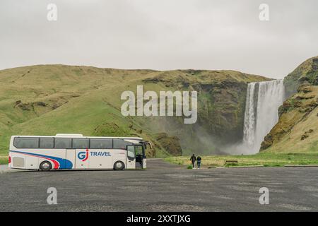 Cascade de Skogafoss, Islande - 25 mai 2024 : célèbre cascade de Skogafoss dans le sud de l'Islande avec un bus touristique Banque D'Images