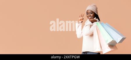 Femme heureuse en pull et chapeau montrant heureux sacs à provisions Banque D'Images