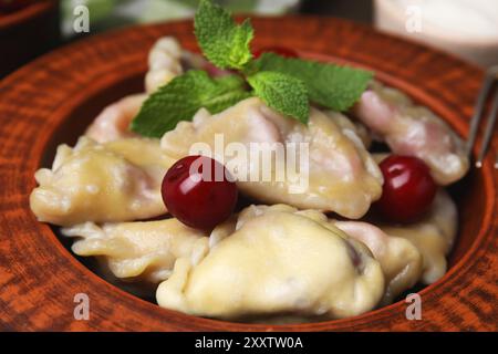 Boulettes ukrainiennes traditionnelles (varenyky) avec cerises sur assiette, gros plan Banque D'Images