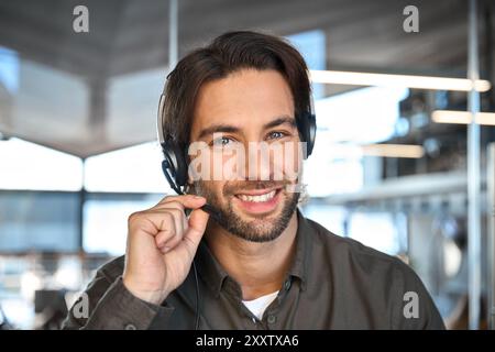 Portrait d'un jeune homme heureux agent de centre d'appels de service à la clientèle portant un casque. Banque D'Images