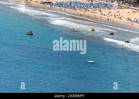 Photo de la ville de Benidorm en Espagne en été montrant les gens sur la célèbre plage de Levante et les bateaux pour enfants et pédalos utilisés en th Banque D'Images